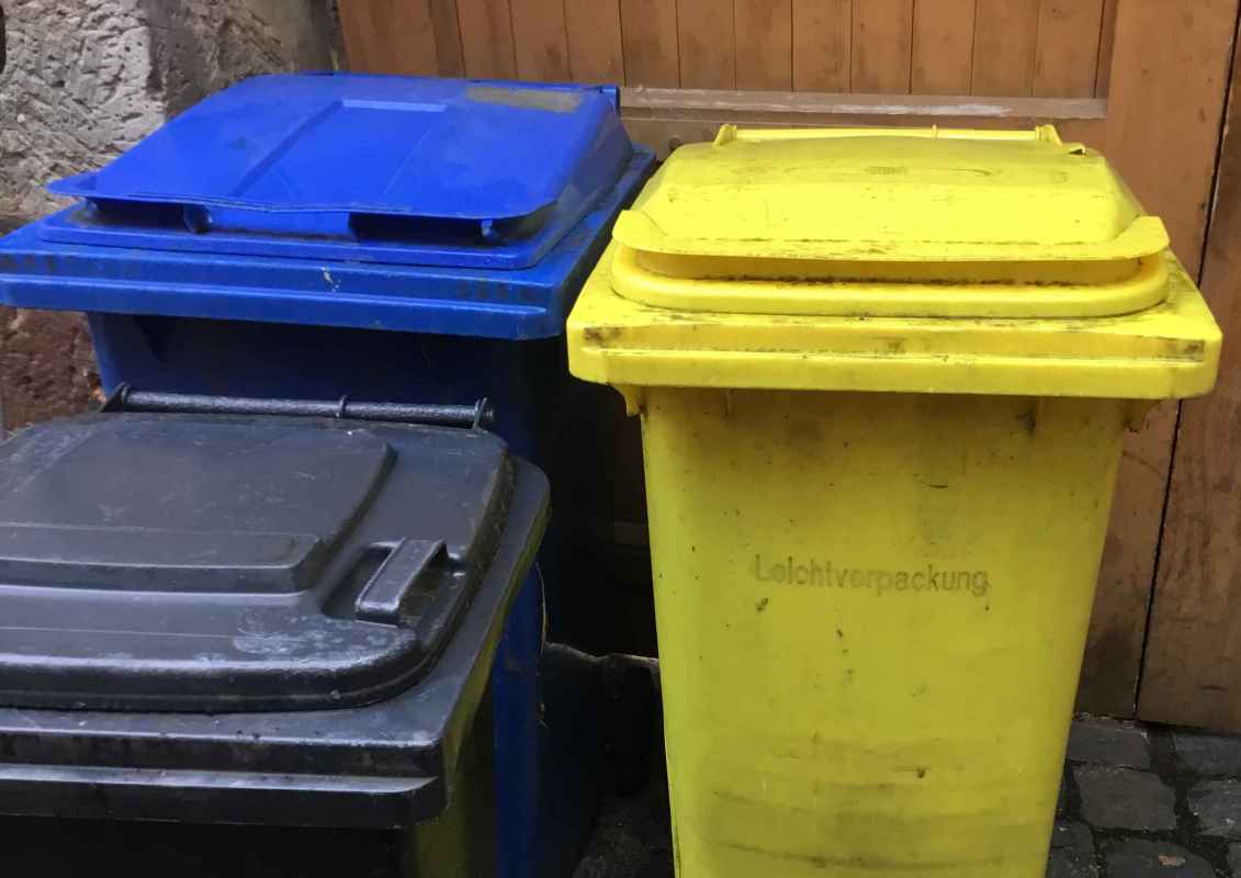 Symbolbild "Abfall und Müll". Zu sehen sind drei unterschiedliche Mülltonnen.